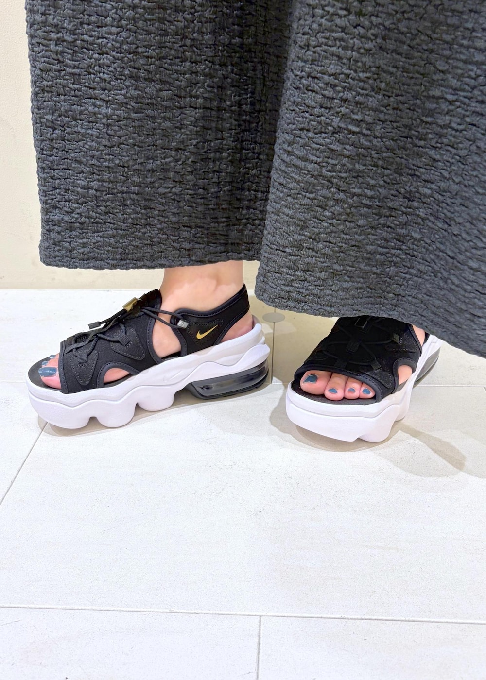 ブラック系のサンダル、ホワイト系のニット/セーター、ブラック系のワンピースを着用したレディースの夏コーディネートの9枚目の写真