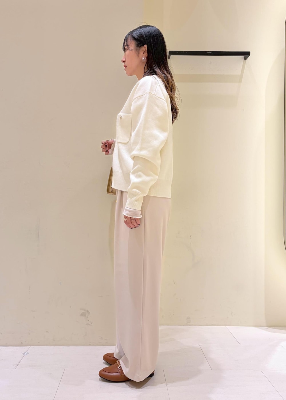 ホワイト系のTシャツ/カットソー、イエロー系のローファー、ベージュ系のボストンバッグを着用したレディースの冬コーディネートの5枚目の写真