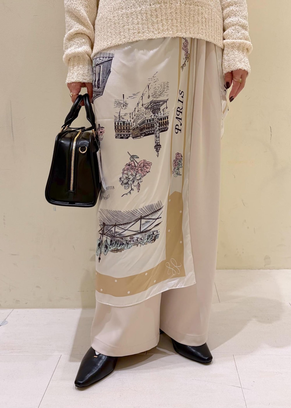 ブラック系のボストンバッグ、ベージュ系のその他パンツ、ホワイト系のニット/セーターを着用したレディースの冬コーディネートの7枚目の写真