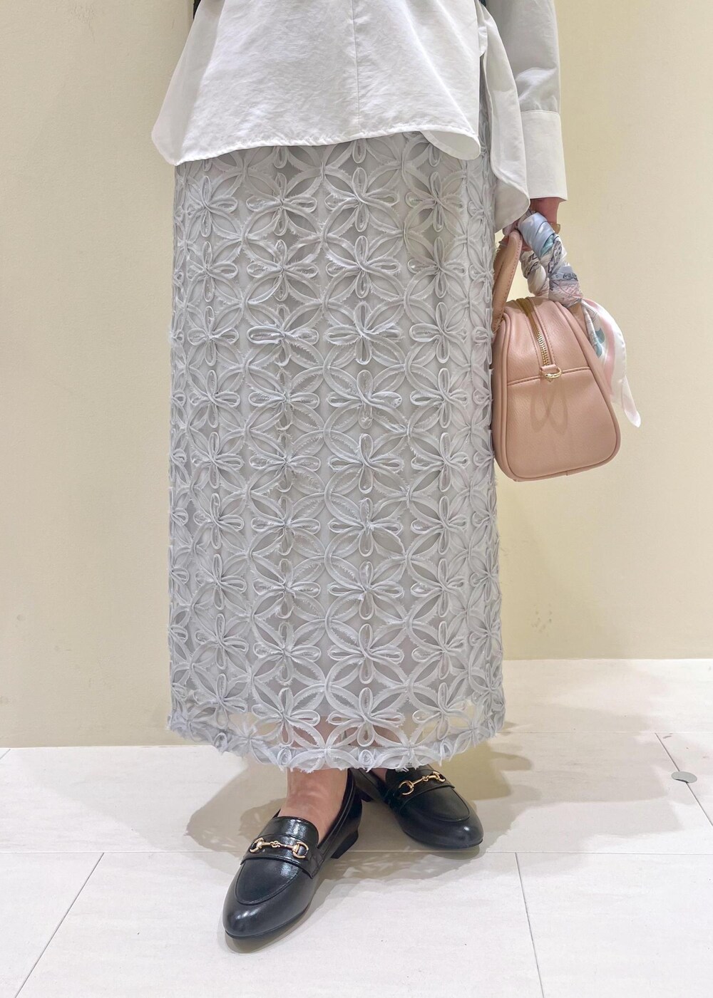 ブラック系のローファー、グレー系のスカート、ホワイト系のシャツ/ブラウスを着用したレディースの春コーディネートの6枚目の写真
