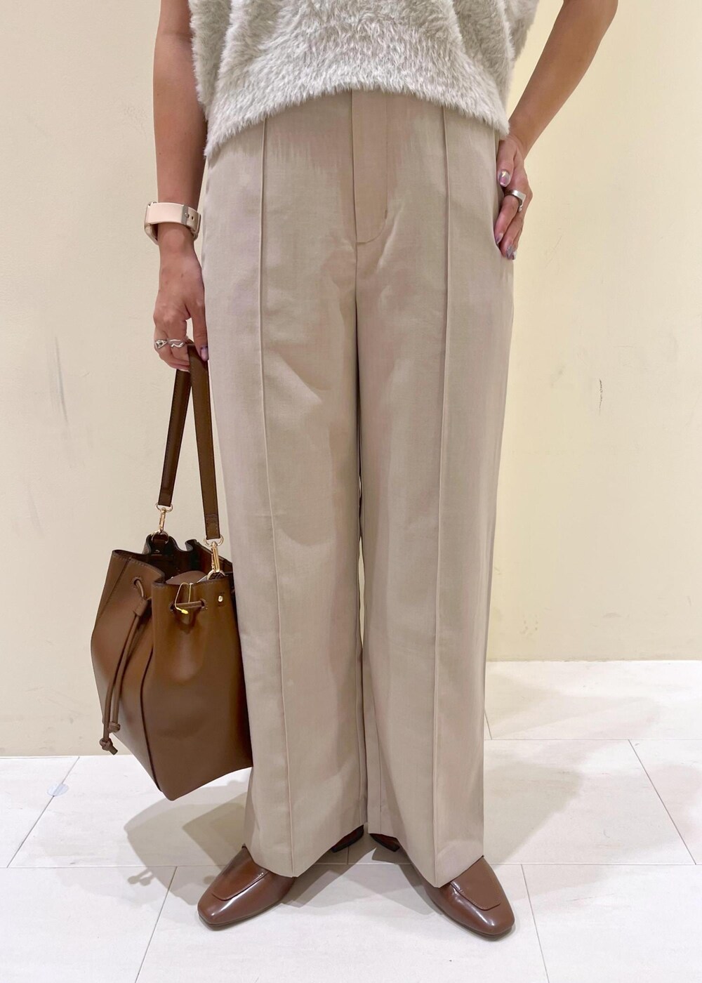 イエロー系のローファー、ベージュ系のその他パンツ、ブラウン系のショルダーバッグを着用したレディースの夏コーディネートの7枚目の写真