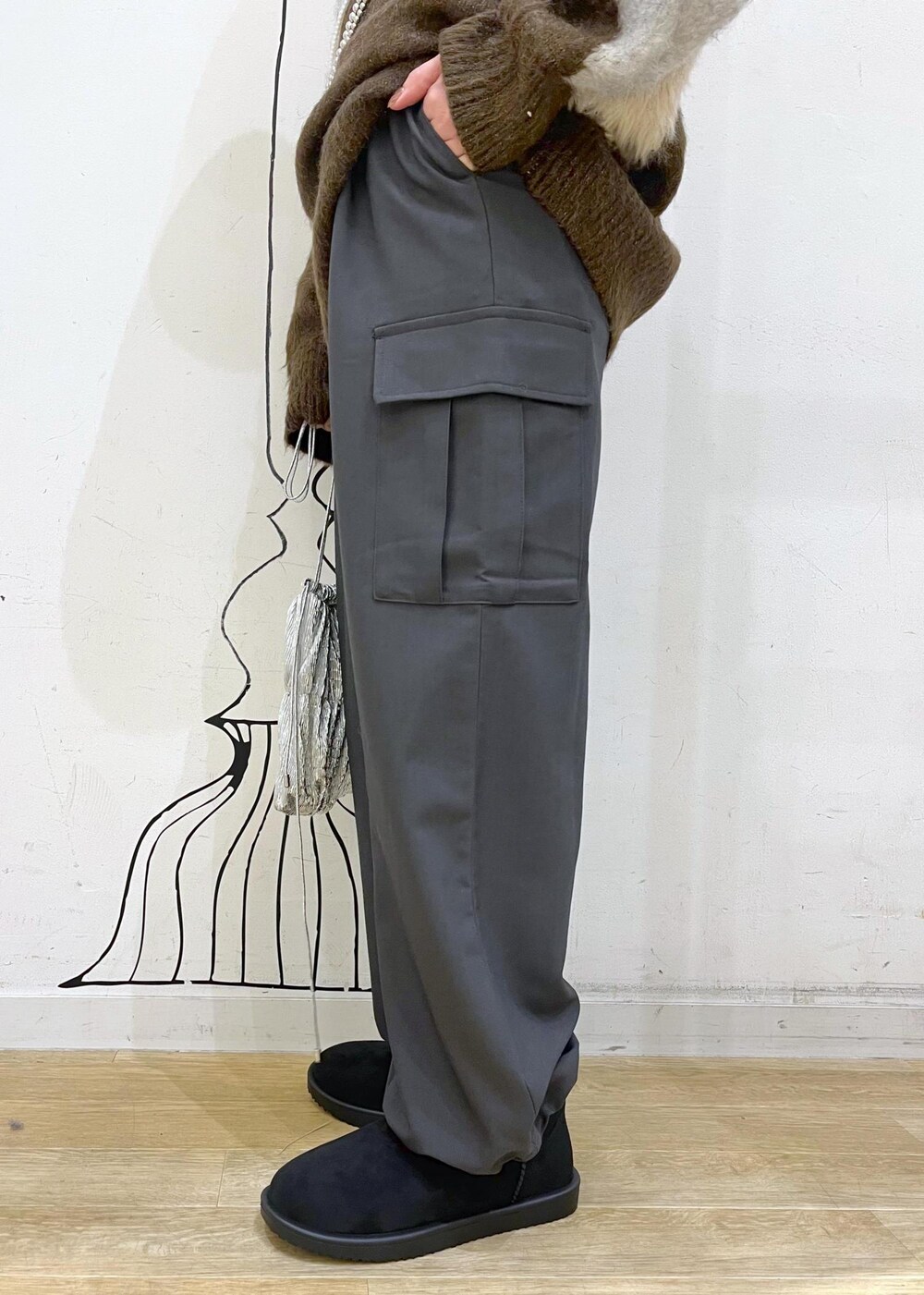 グレー系のカーゴパンツ、シルバー系のショルダーバッグ、ブラウン系のニット/セーターを着用したレディースの秋コーディネートの6枚目の写真