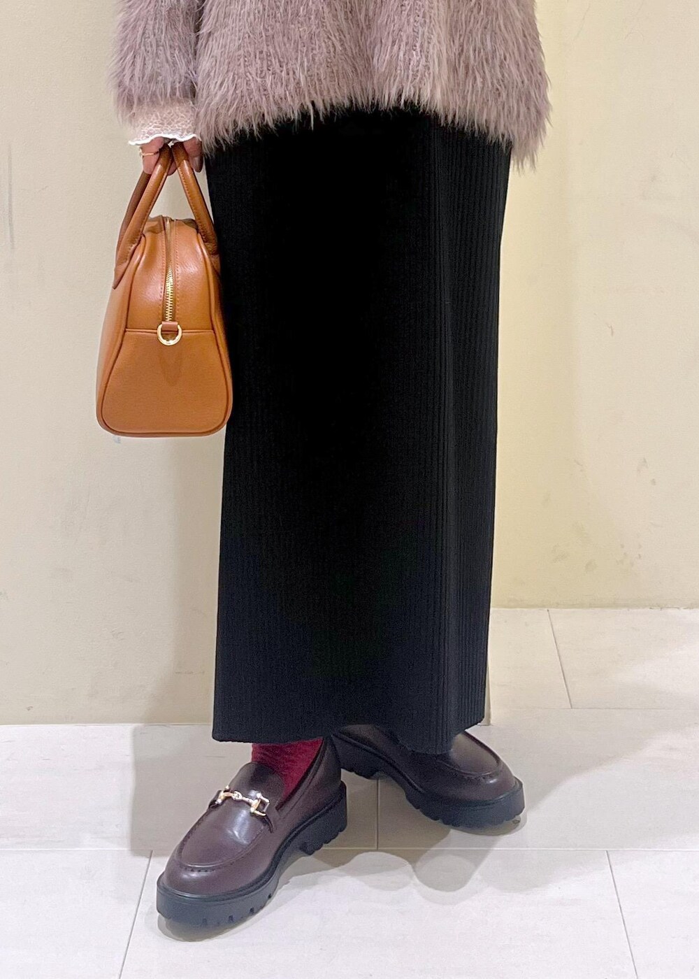 ホワイト系のTシャツ/カットソー、ブラウン系のニット/セーター、ブラウン系のローファーを着用したレディースの秋コーディネートの7枚目の写真