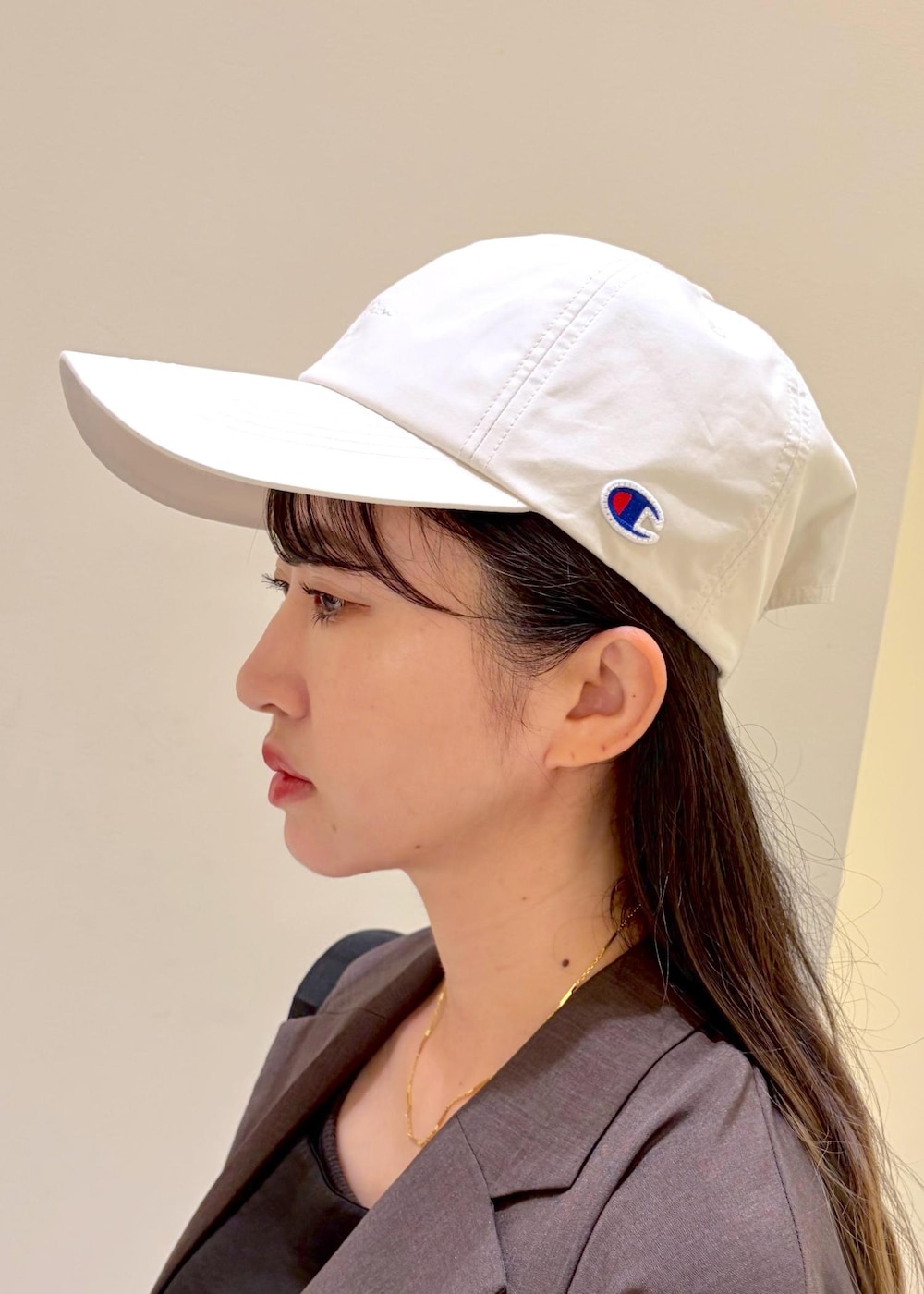 ブルー系のデニムパンツ、ブラウン系のテーラードジャケット、ブラック系のキャミソールを着用したレディースの夏コーディネートの5枚目の写真