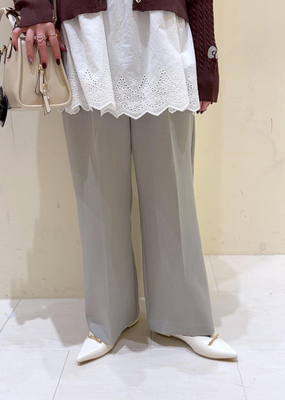 ベージュ系のショルダーバッグ、ホワイト系のキャミソール、ブラウン系のカーディガン/ボレロを着用したレディースの春コーディネートの7枚目の写真