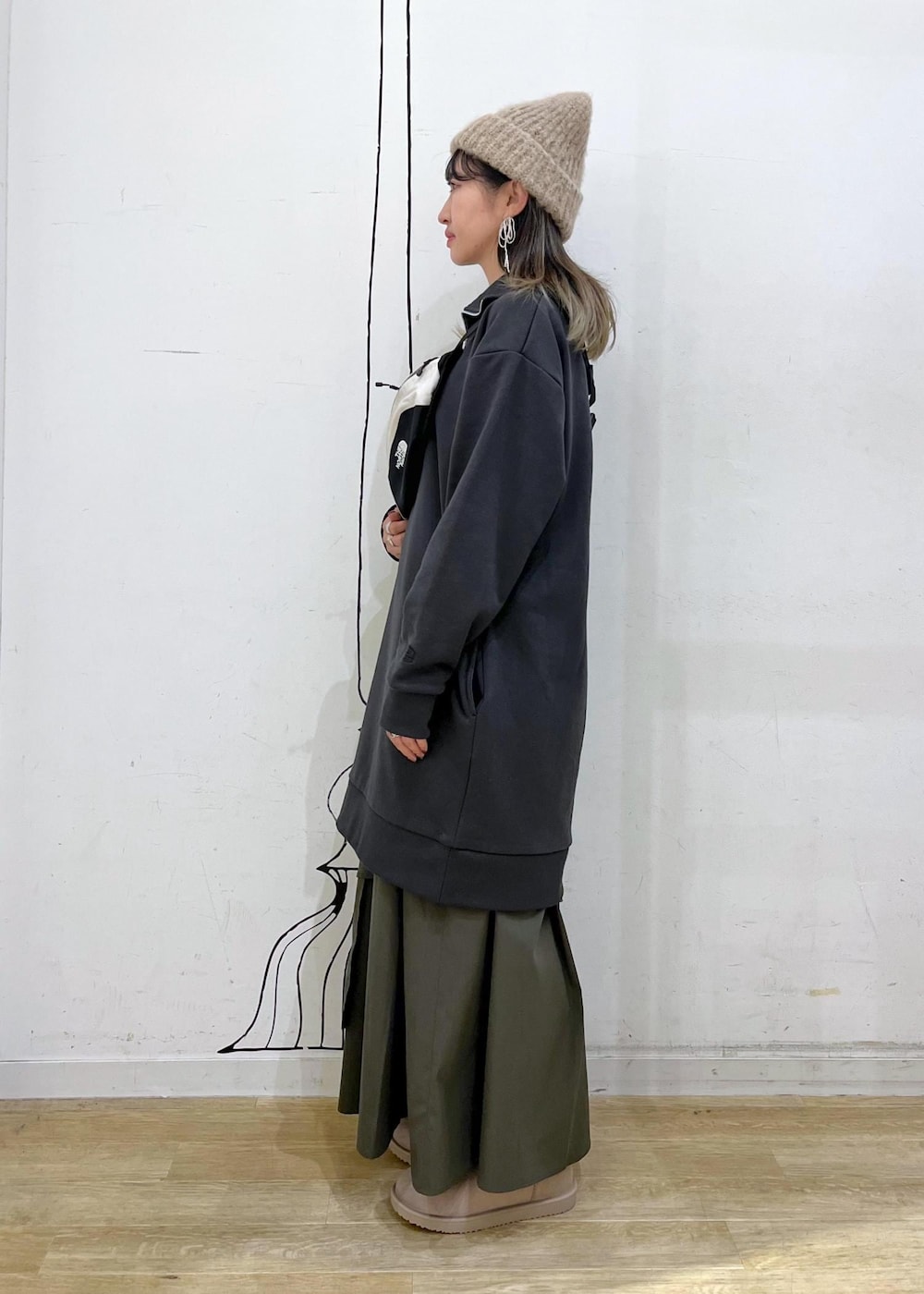 グリーン系のスカート、グレー系のワンピース、ホワイト系のボディバッグ/ウエストポーチを着用したレディースの秋コーディネートの4枚目の写真