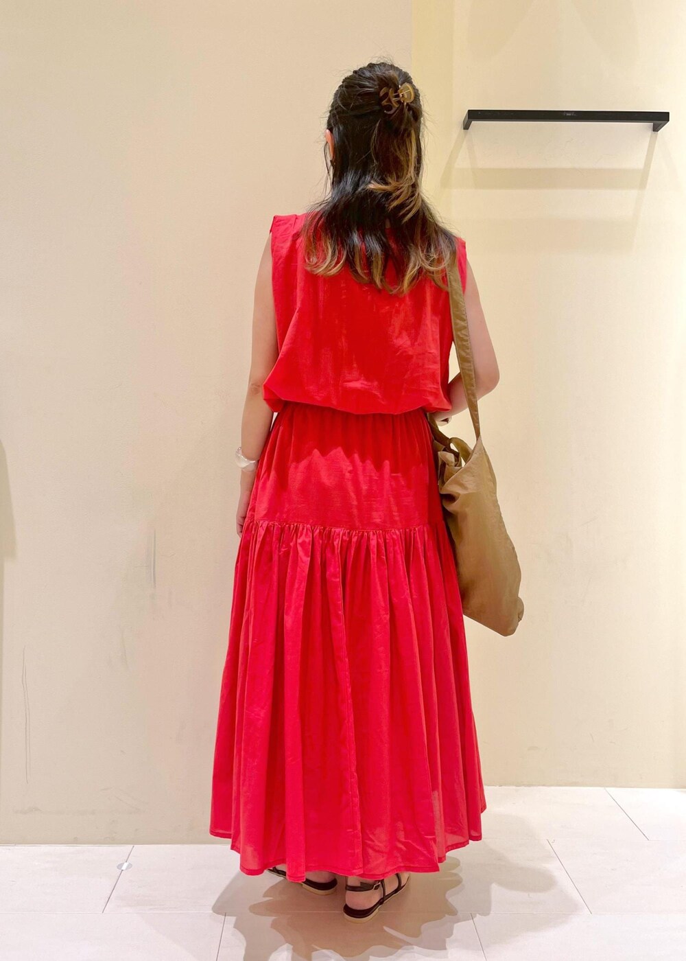 ブラウン系のサンダル、レッド系のワンピース、ブラウン系のトートバッグを着用したレディースの夏コーディネートの3枚目の写真