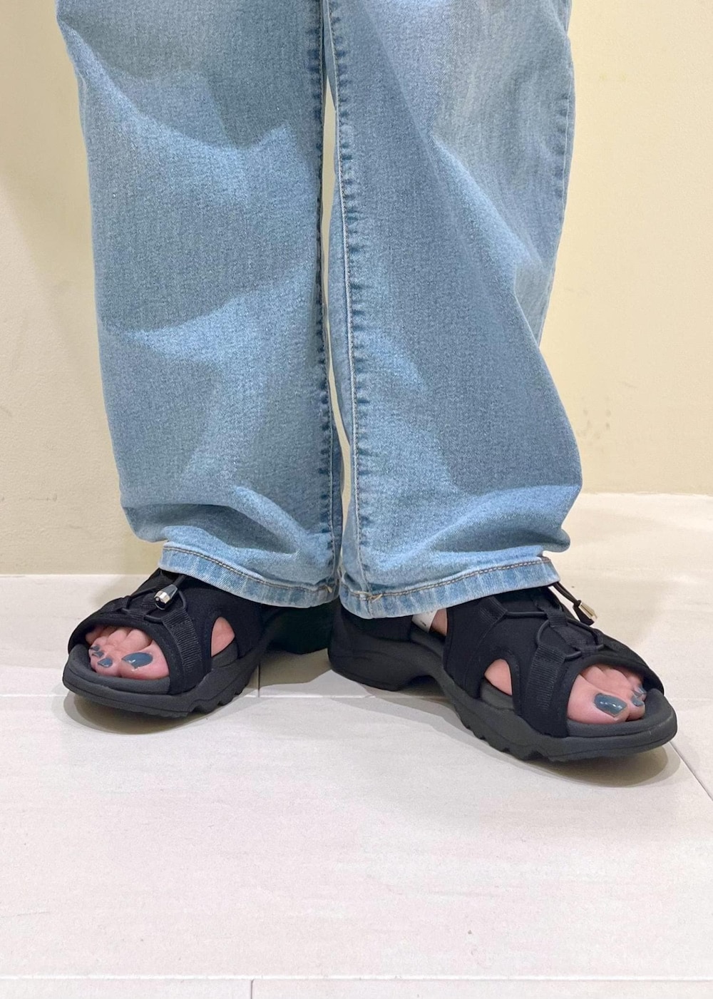 ブルー系のデニムパンツ、ホワイト系のニット/セーター、ブラック系のサンダルを着用したレディースの夏コーディネートの10枚目の写真