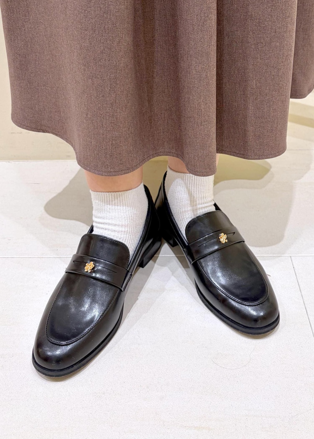 ベージュ系のスカート、グレー系のカーディガン/ボレロ、ホワイト系のTシャツ/カットソーを着用したレディースの冬コーディネートの10枚目の写真