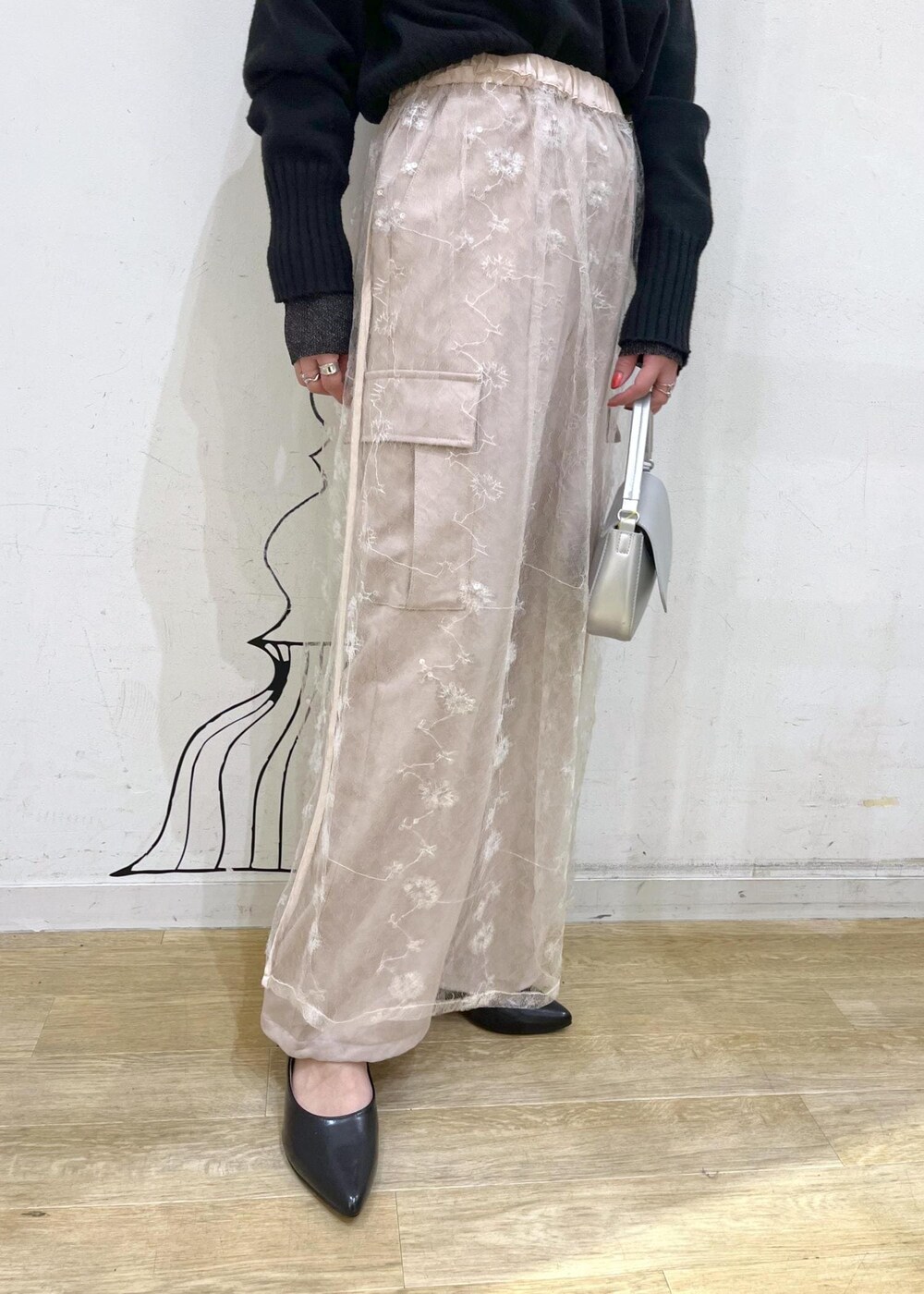 ブラック系のニット/セーター、ホワイト系のスカート、ブラック系のパンプスを着用したレディースの冬コーディネートの7枚目の写真