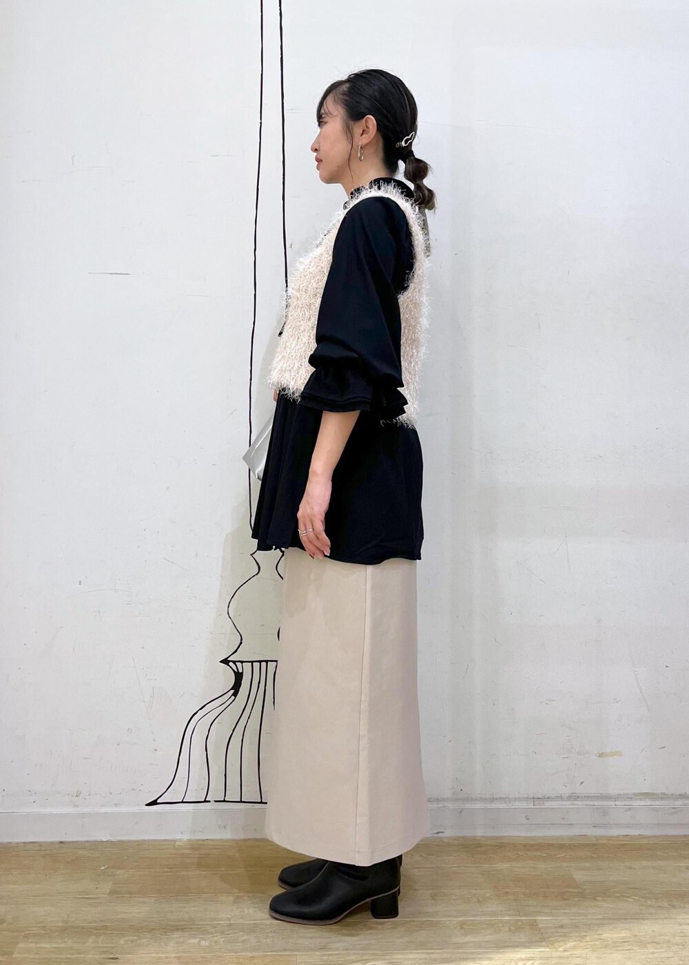 ベージュ系のスカート、ベージュ系のベスト、ブラック系のシャツ/ブラウスを着用したレディースの秋コーディネートの4枚目の写真