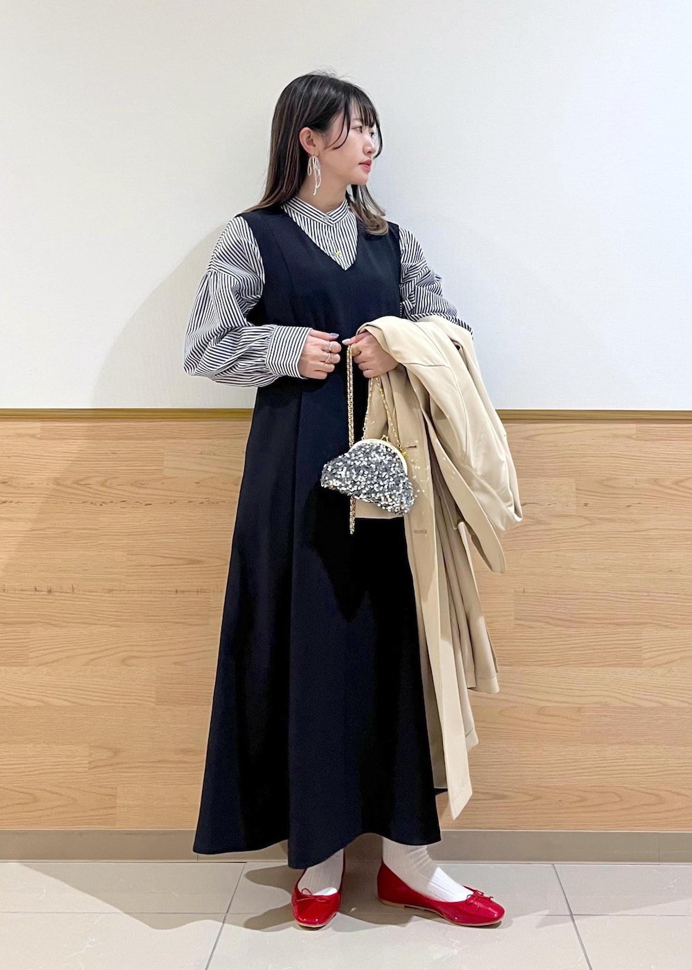 グレー系のショルダーバッグ、ブルー系のシャツ/ブラウス、ベージュ系のトレンチコートを着用したレディースの春コーディネートの2枚目の写真