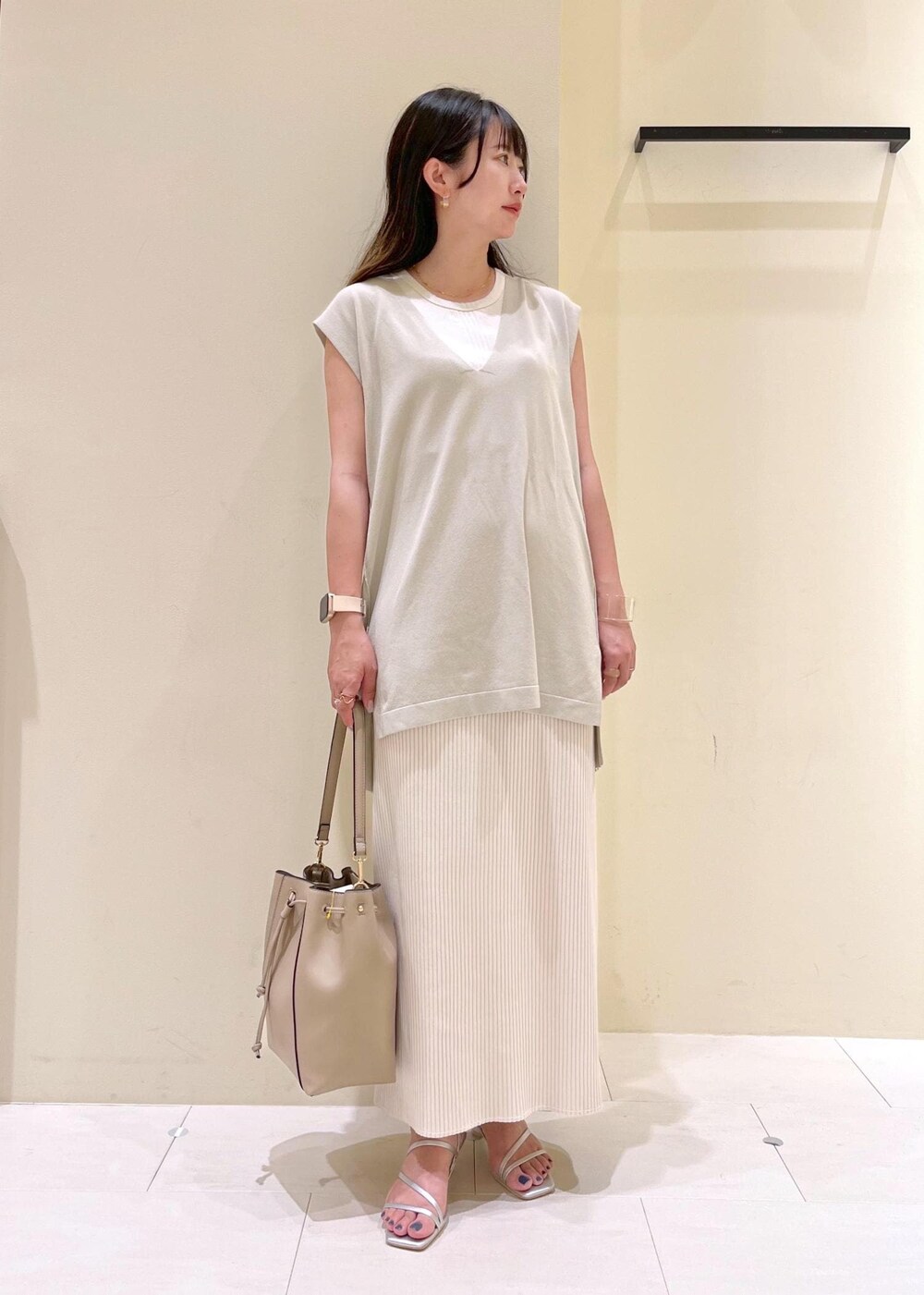 ベージュ系のタンクトップ、シルバー系のサンダル、ベージュ系のショルダーバッグを着用したレディースの夏コーディネートの2枚目の写真