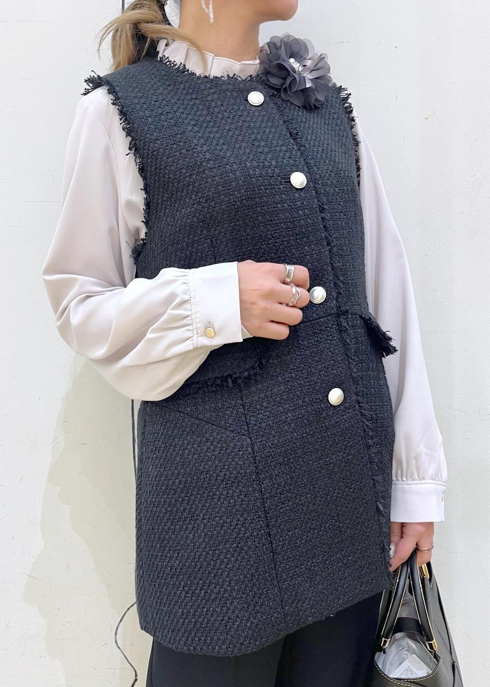 ブラック系のローファー、ブラック系のショルダーバッグ、ブルー系のベストを着用したレディースの冬コーディネートの5枚目の写真