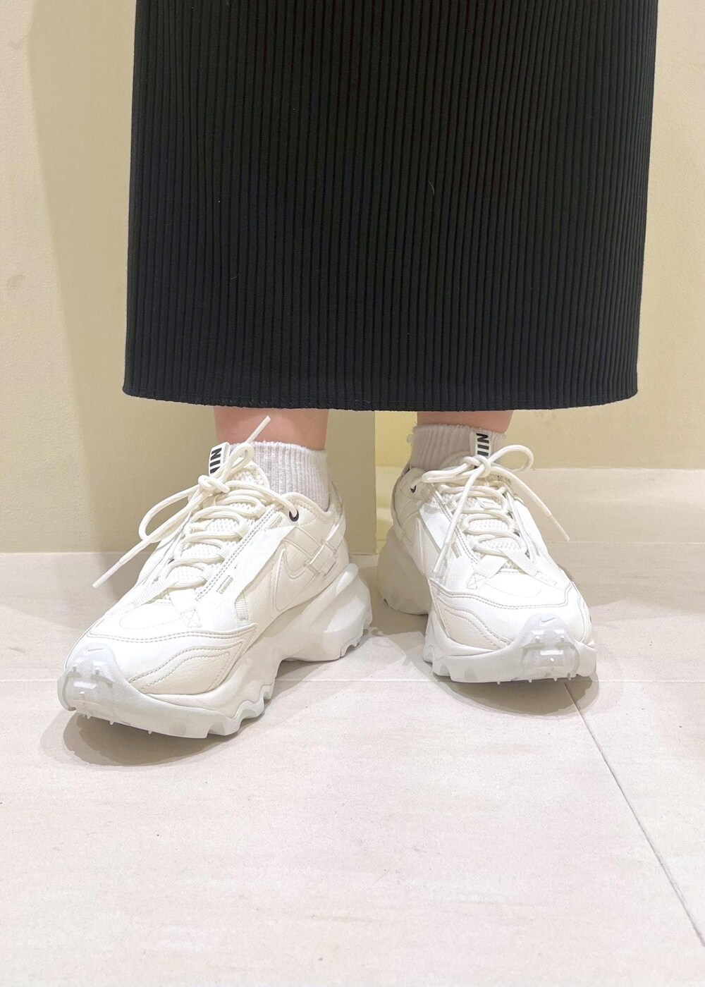 シルバー系のトートバッグ、ブラック系のスカート、ブルー系のシャツ/ブラウスを着用したレディースの春コーディネートの9枚目の写真