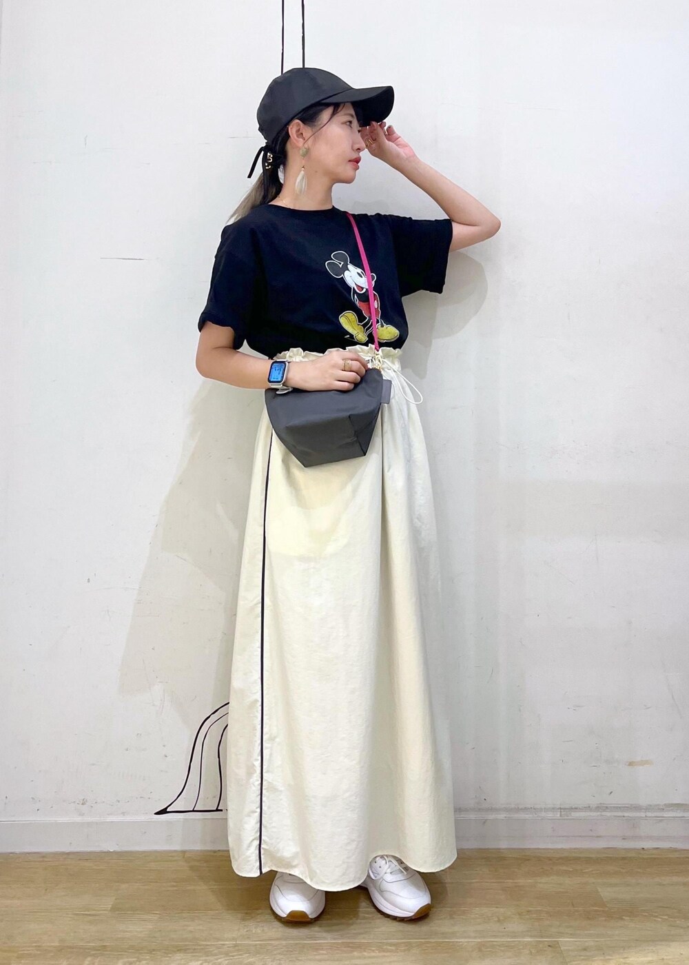 ホワイト系のスニーカー、グレー系のショルダーバッグ、ホワイト系のスカートを着用したレディースの夏コーディネートの2枚目の写真