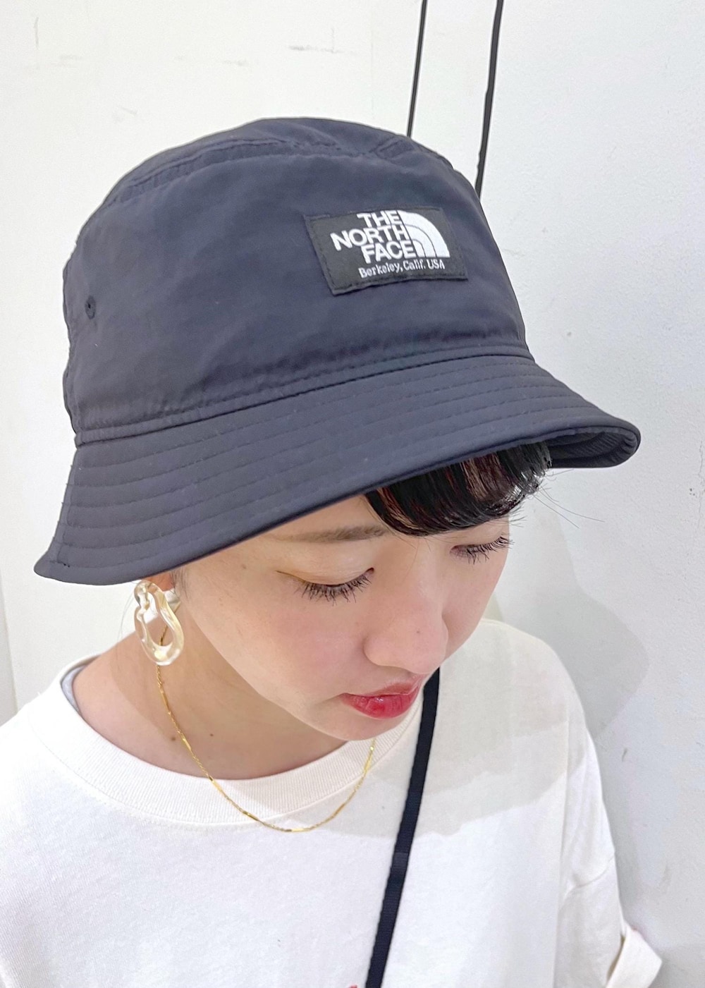 グレー系のその他パンツ、ホワイト系のTシャツ/カットソー、ブラック系のショルダーバッグを着用したレディースの夏コーディネートの6枚目の写真