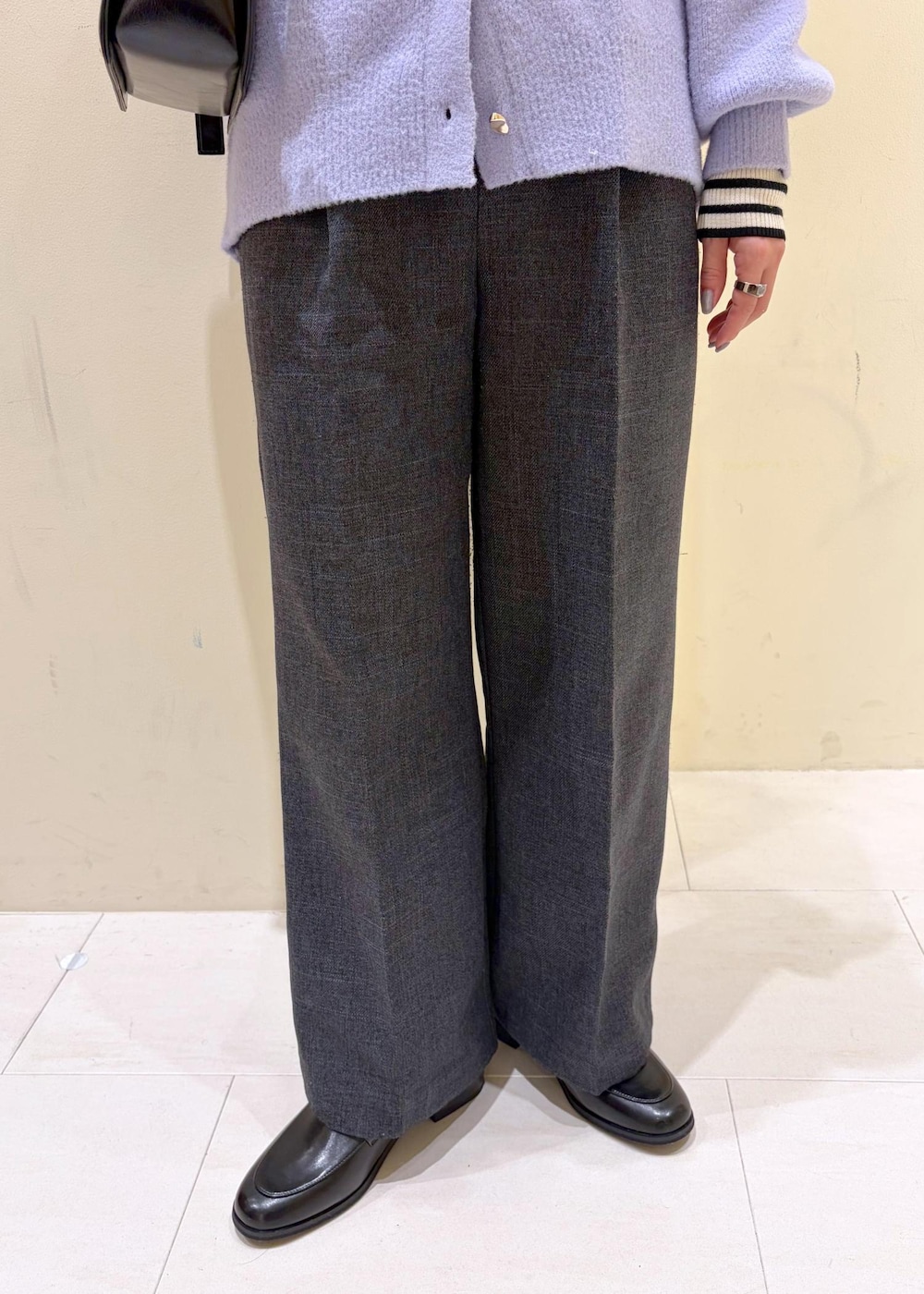 ブラック系のショルダーバッグ、ホワイト系のニット/セーター、グレー系のスラックスを着用したレディースの冬コーディネートの9枚目の写真