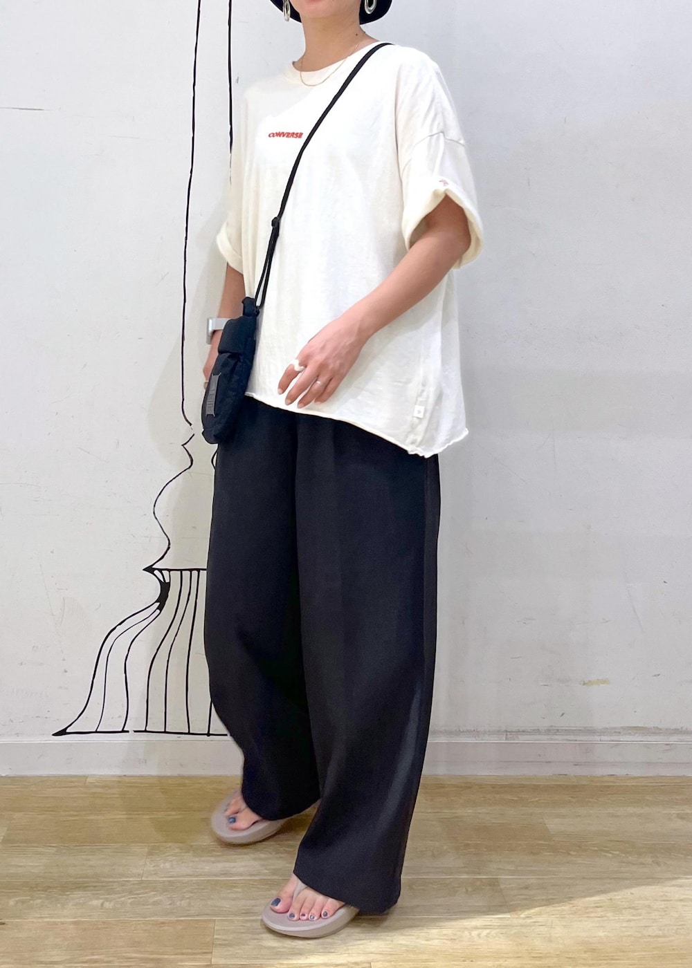 グレー系のその他パンツ、ホワイト系のTシャツ/カットソー、ブラック系のショルダーバッグを着用したレディースの夏コーディネートの3枚目の写真