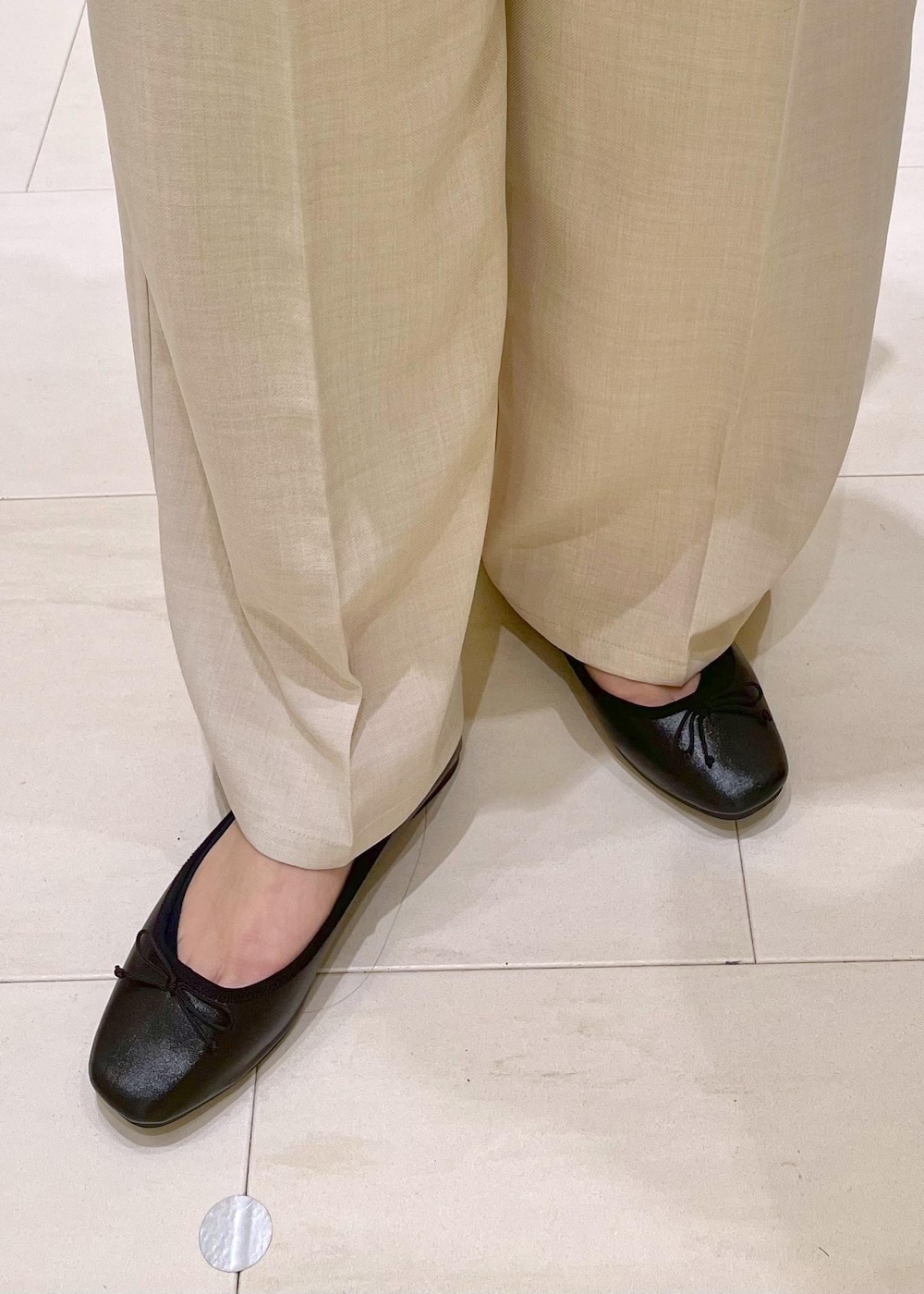 ブラック系のハンドバッグ、グレー系のニット/セーター、ブラック系のバレエシューズを着用したレディースの春コーディネートの9枚目の写真