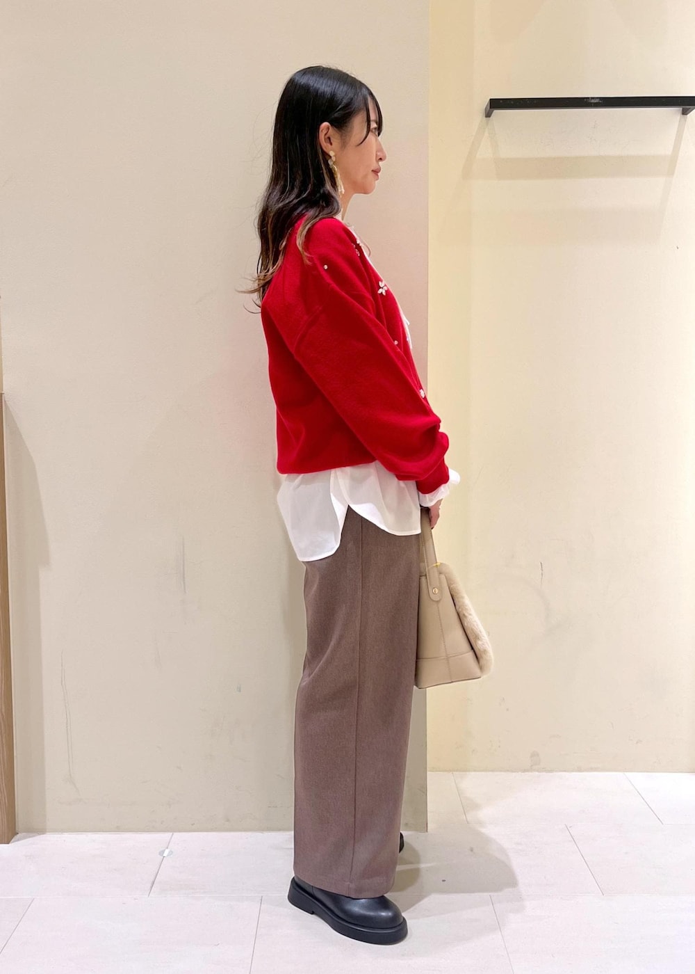 ベージュ系のスラックス、ホワイト系のシャツ/ブラウス、ブラック系のブーツを着用したレディースの冬コーディネートの2枚目の写真