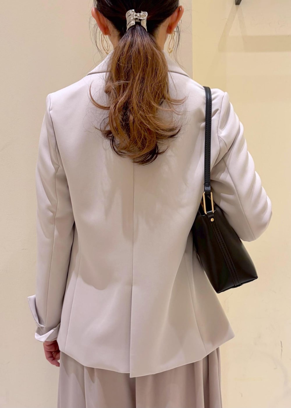 ベージュ系のその他パンツ、ブラック系のショルダーバッグ、グレー系のテーラードジャケットを着用したレディースの冬コーディネートの7枚目の写真