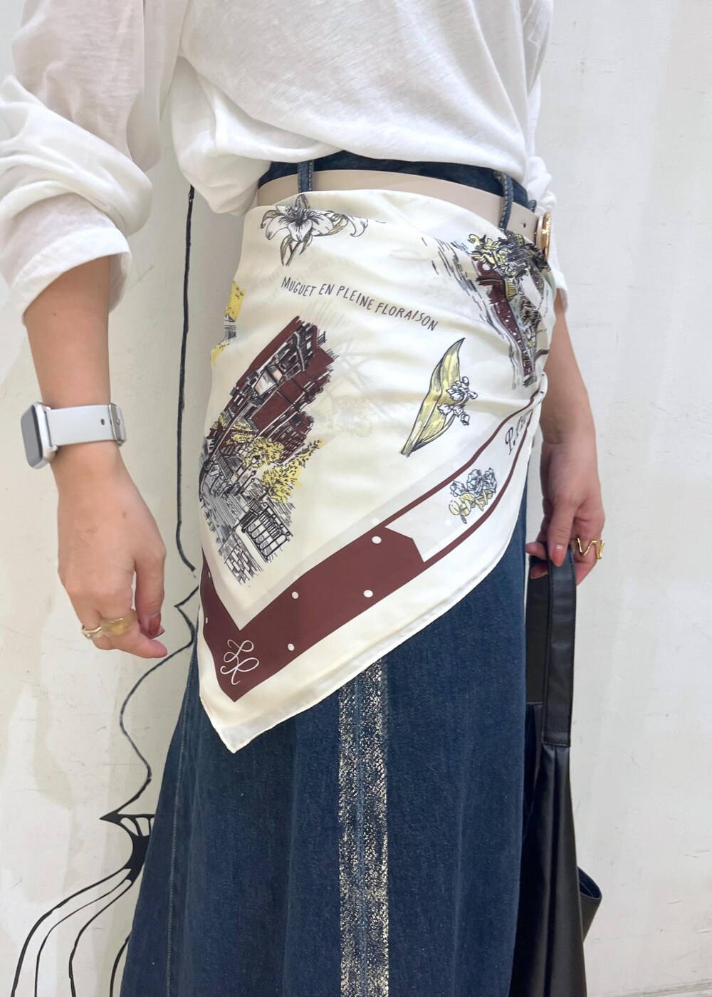 ブラック系のパンプス、ブラック系のトートバッグ、ブルー系のデニムスカートを着用したレディースの秋コーディネートの6枚目の写真