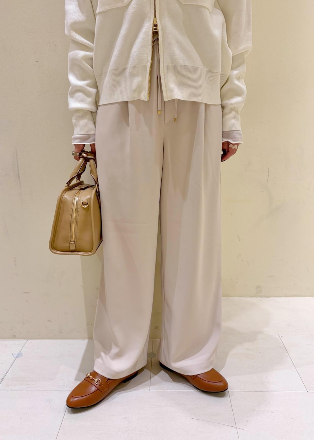 ホワイト系のTシャツ/カットソー、イエロー系のローファー、ベージュ系のボストンバッグを着用したレディースの冬コーディネートの8枚目の写真