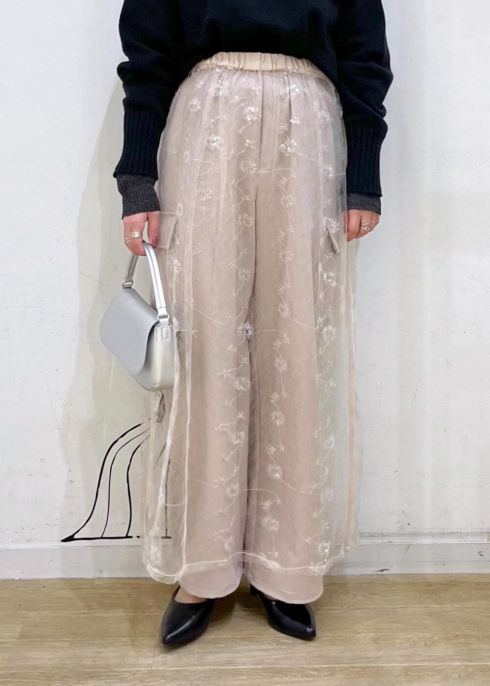 ブラック系のニット/セーター、ホワイト系のスカート、ブラック系のパンプスを着用したレディースの冬コーディネートの6枚目の写真