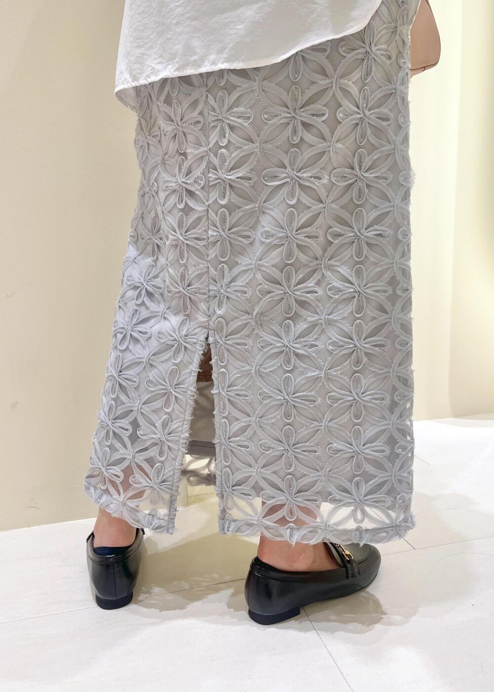 ブラック系のローファー、グレー系のスカート、ホワイト系のシャツ/ブラウスを着用したレディースの春コーディネートの7枚目の写真