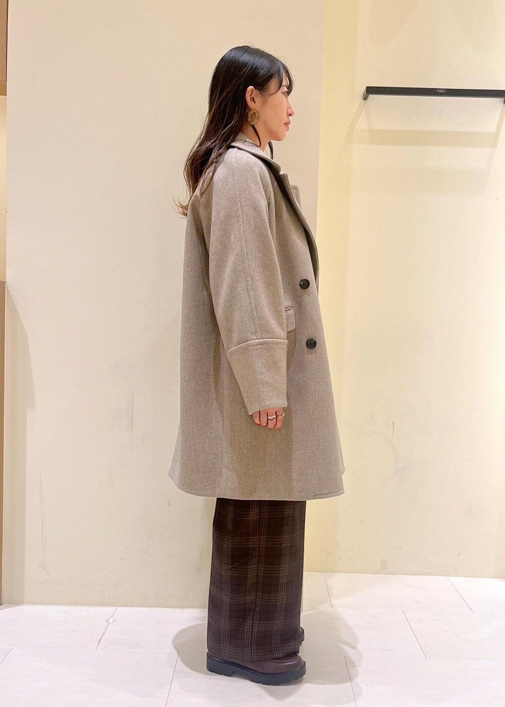 ブラック系のショルダーバッグ、レッド系のニット/セーター、ブラウン系のピーコートを着用したレディースの秋コーディネートの2枚目の写真