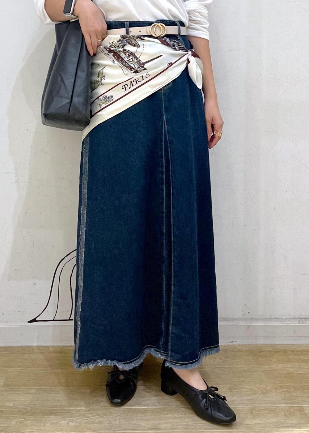 ブラック系のパンプス、ブラック系のトートバッグ、ブルー系のデニムスカートを着用したレディースの秋コーディネートの7枚目の写真