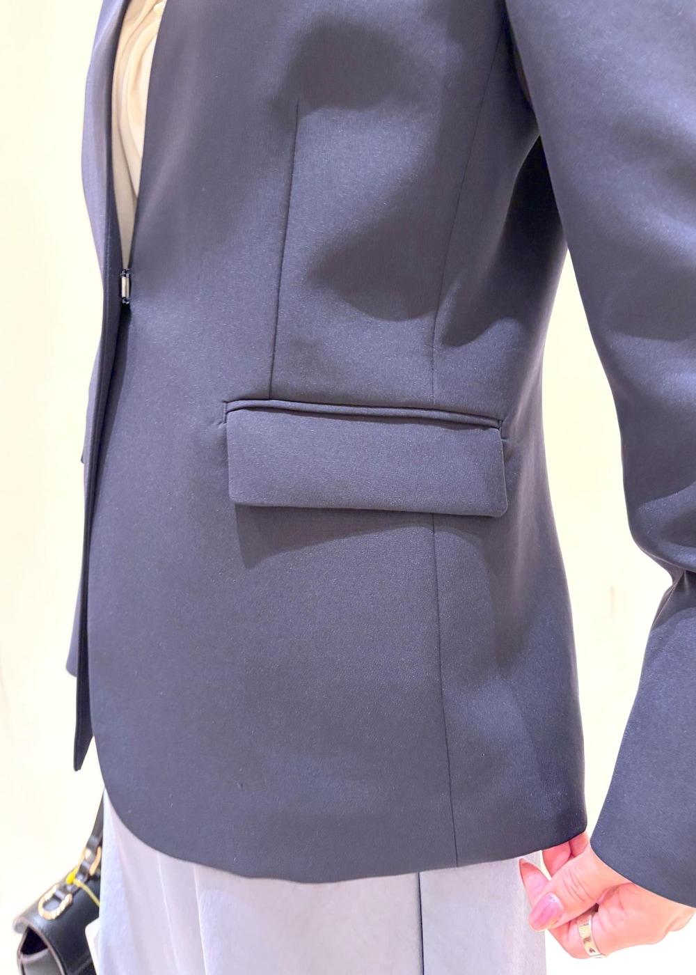 ホワイト系のシャツ/ブラウス、ブルー系のノーカラージャケット、ブラック系のショルダーバッグを着用したレディースの冬コーディネートの6枚目の写真