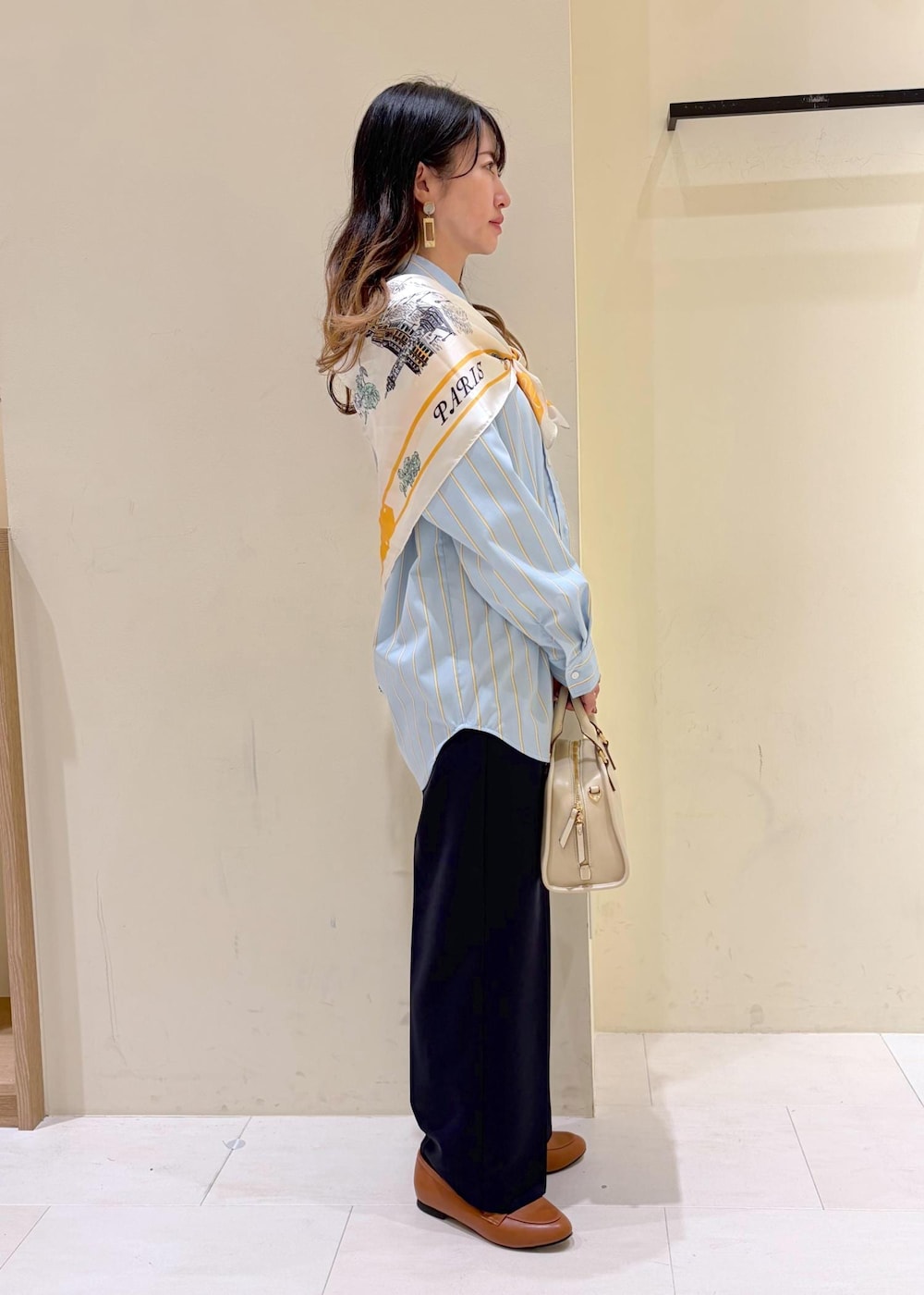 イエロー系のローファー、ホワイト系のボストンバッグ、ブルー系のその他パンツを着用したレディースの春コーディネートの2枚目の写真