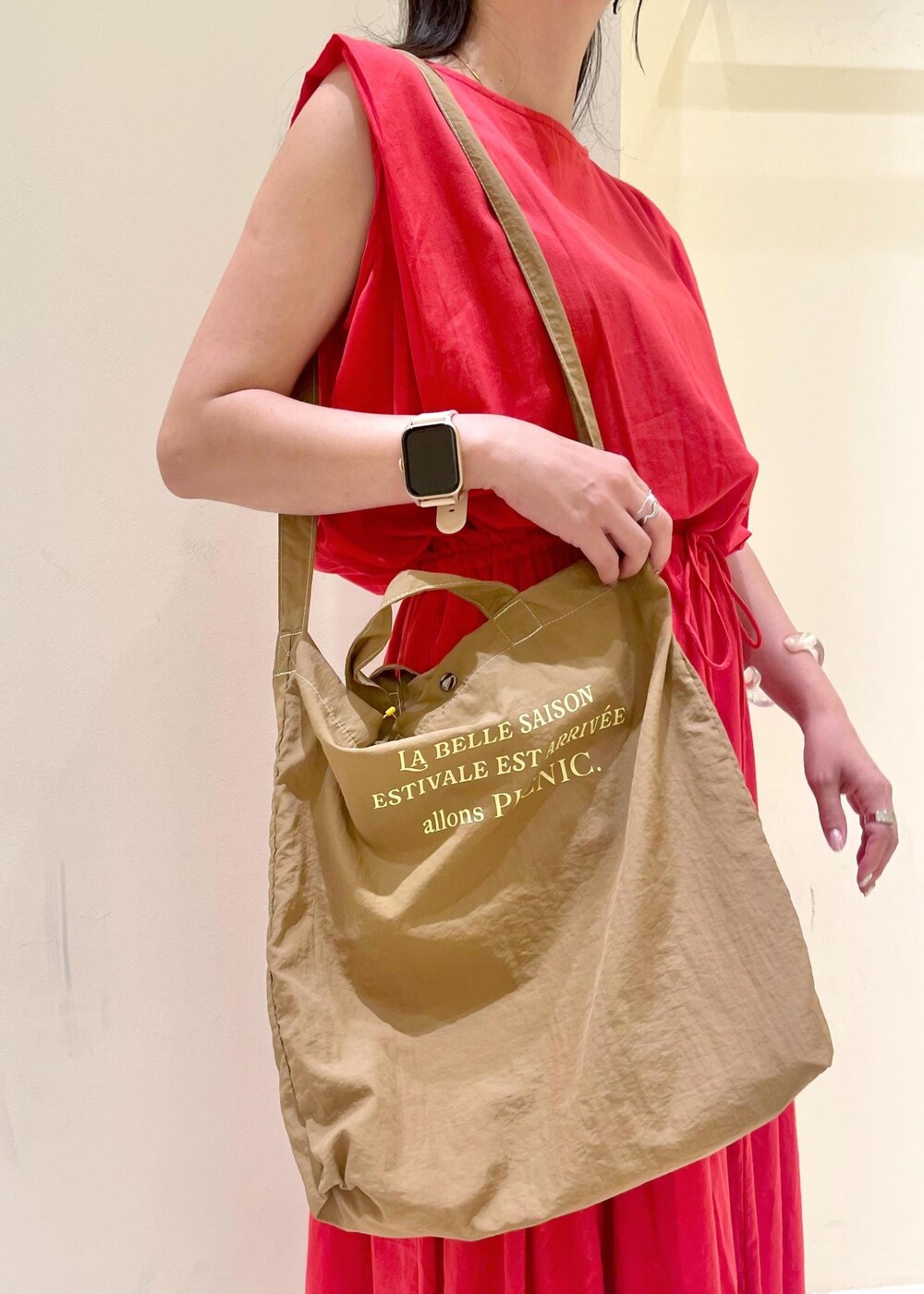 ブラウン系のサンダル、レッド系のワンピース、ブラウン系のトートバッグを着用したレディースの夏コーディネートの9枚目の写真