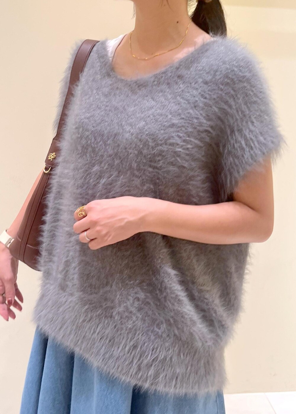 グレー系のタンクトップ、ブルー系のスカート、グレー系のベストを着用したレディースの秋コーディネートの5枚目の写真