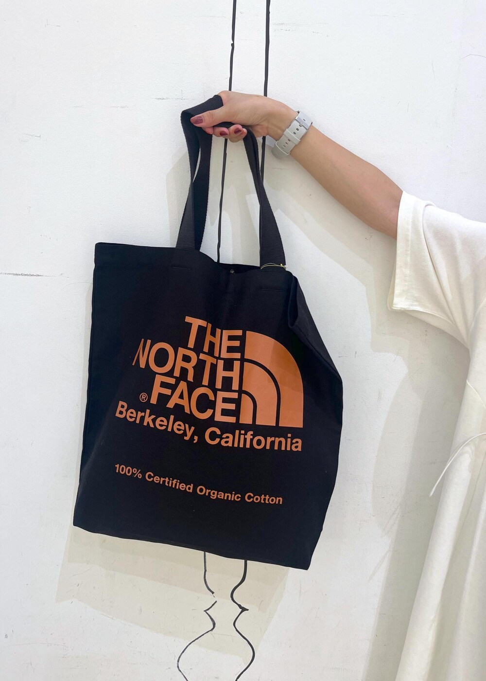 ブラック系のトートバッグ、ブラック系のバレエシューズ、ホワイト系のワンピースを着用したレディースの夏コーディネートの8枚目の写真