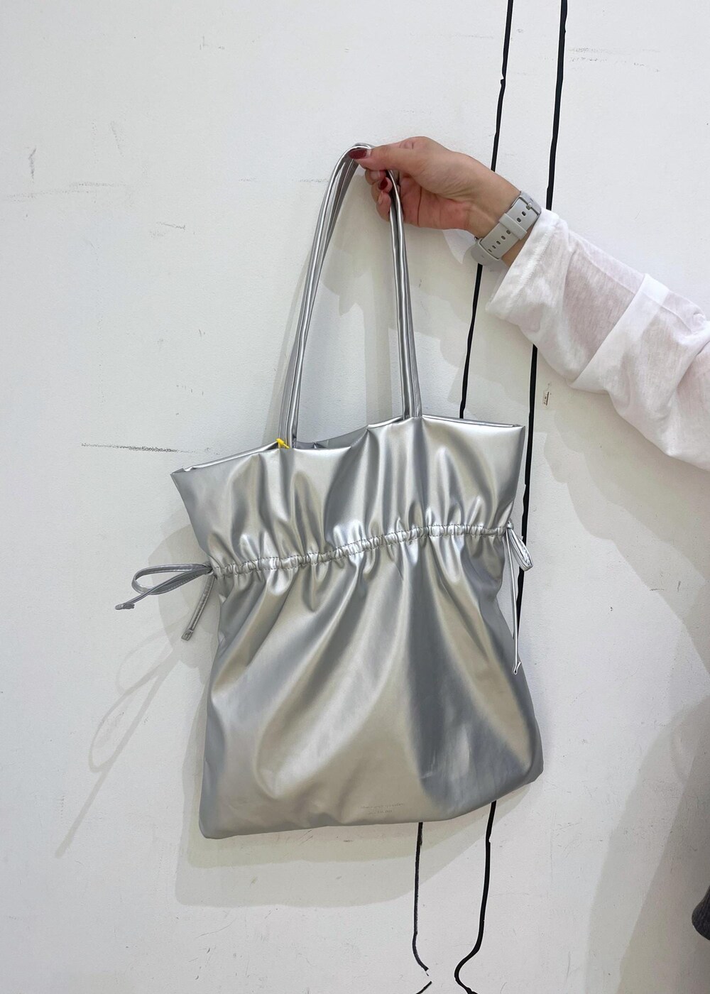 シルバー系のパンプス、グレー系のその他パンツ、シルバー系のトートバッグを着用したレディースの秋コーディネートの9枚目の写真