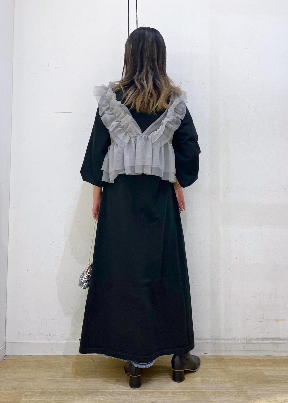 ブルー系のデニムスカート、ブラック系のブーツ、ブラック系のワンピースを着用したレディースの冬コーディネートの4枚目の写真