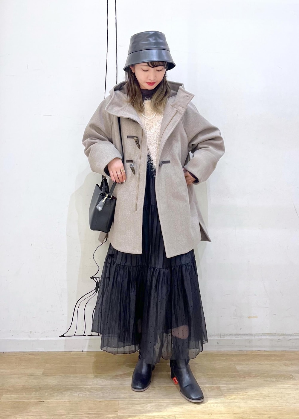 グレー系のTシャツ/カットソー、ベージュ系のカーディガン/ボレロ、ブラック系のブーツを着用したレディースの秋コーディネートの2枚目の写真