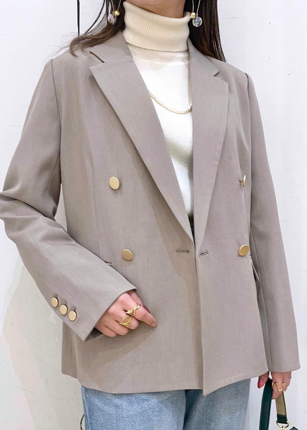 ホワイト系のニット/セーター、ブルー系のデニムパンツ、ブラック系のローファーを着用したレディースの冬コーディネートの6枚目の写真