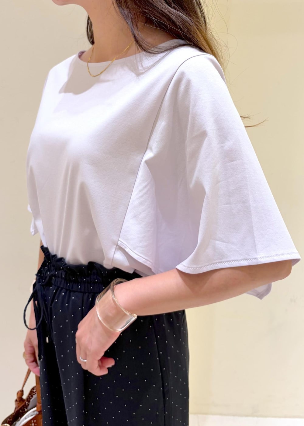 ブラウン系のショルダーバッグ、ブラウン系のサンダル、パープル系のTシャツ/カットソーを着用したレディースの夏コーディネートの5枚目の写真