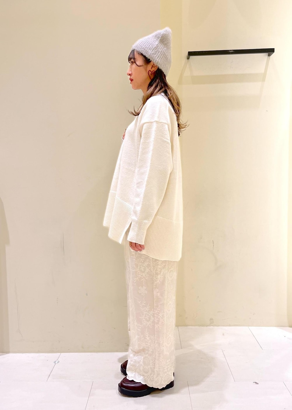 ホワイト系のニット/セーター、ブラウン系のショルダーバッグ、ブラウン系のローファーを着用したレディースの冬コーディネートの2枚目の写真