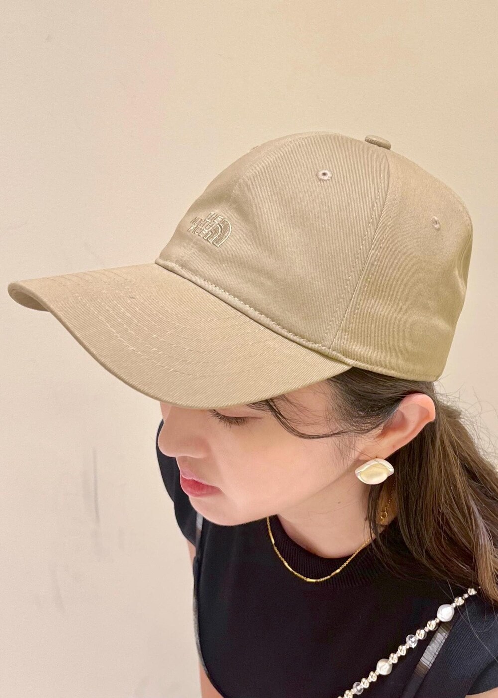 ブラック系のニット/セーター、ホワイト系のサンダル、レッド系のトートバッグを着用したレディースの夏コーディネートの5枚目の写真