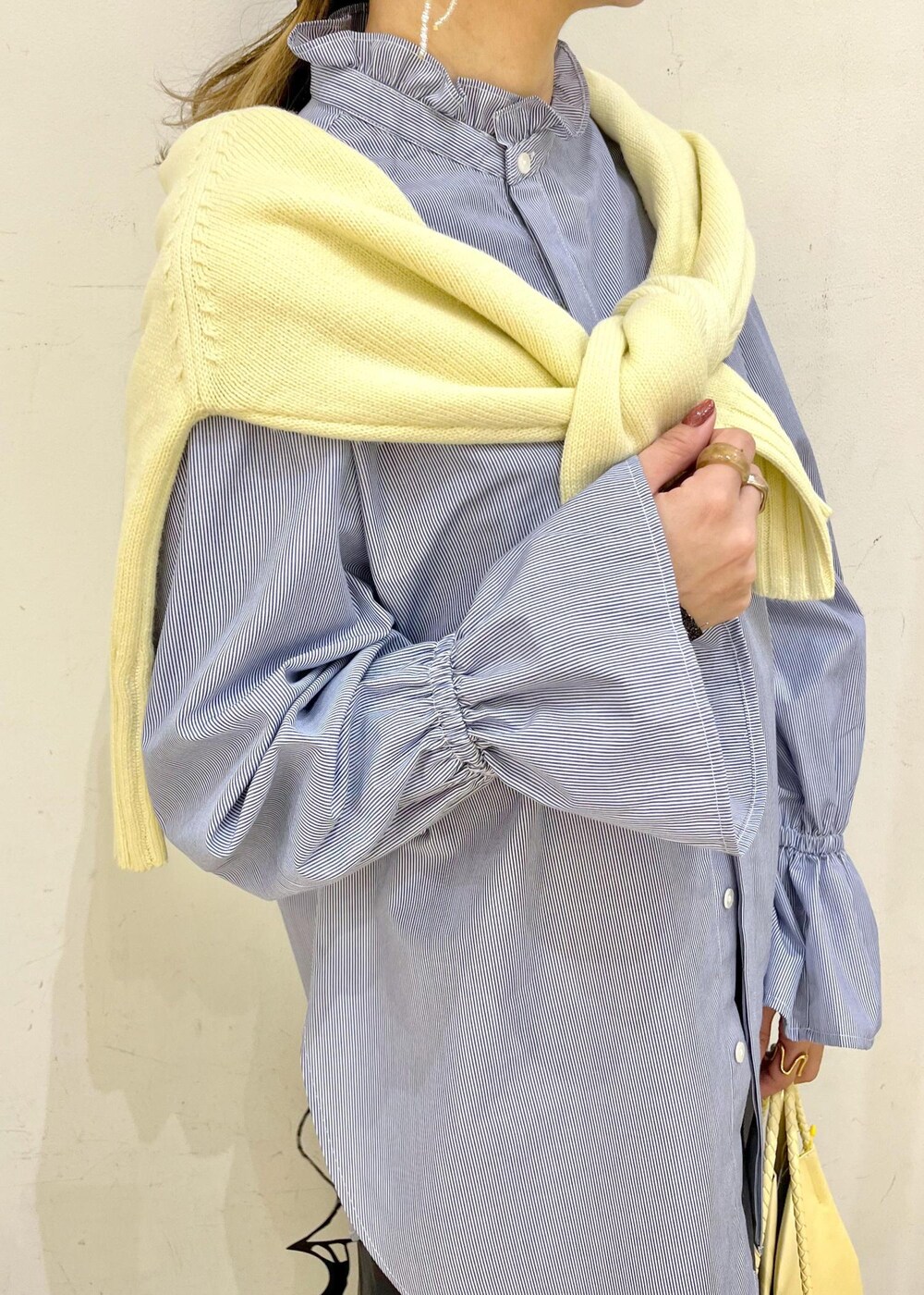 イエロー系のトートバッグ、グレー系のスカート、ブルー系のシャツ/ブラウスを着用したレディースの冬コーディネートの4枚目の写真