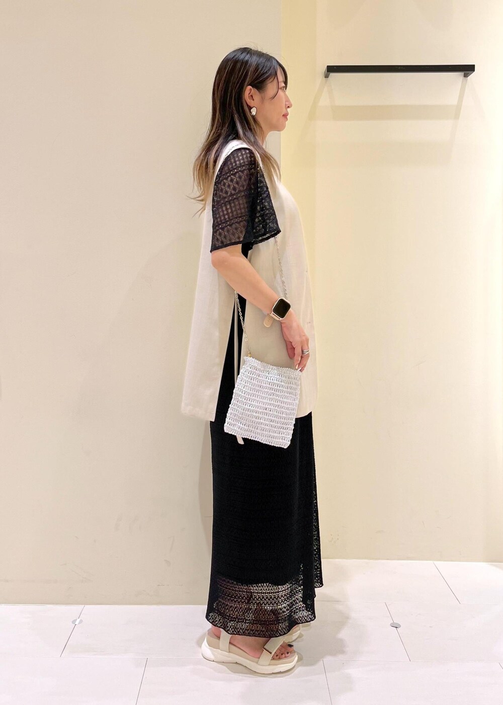 その他のショルダーバッグ、ベージュ系のベスト、ホワイト系のサンダルを着用したレディースの春コーディネートの3枚目の写真