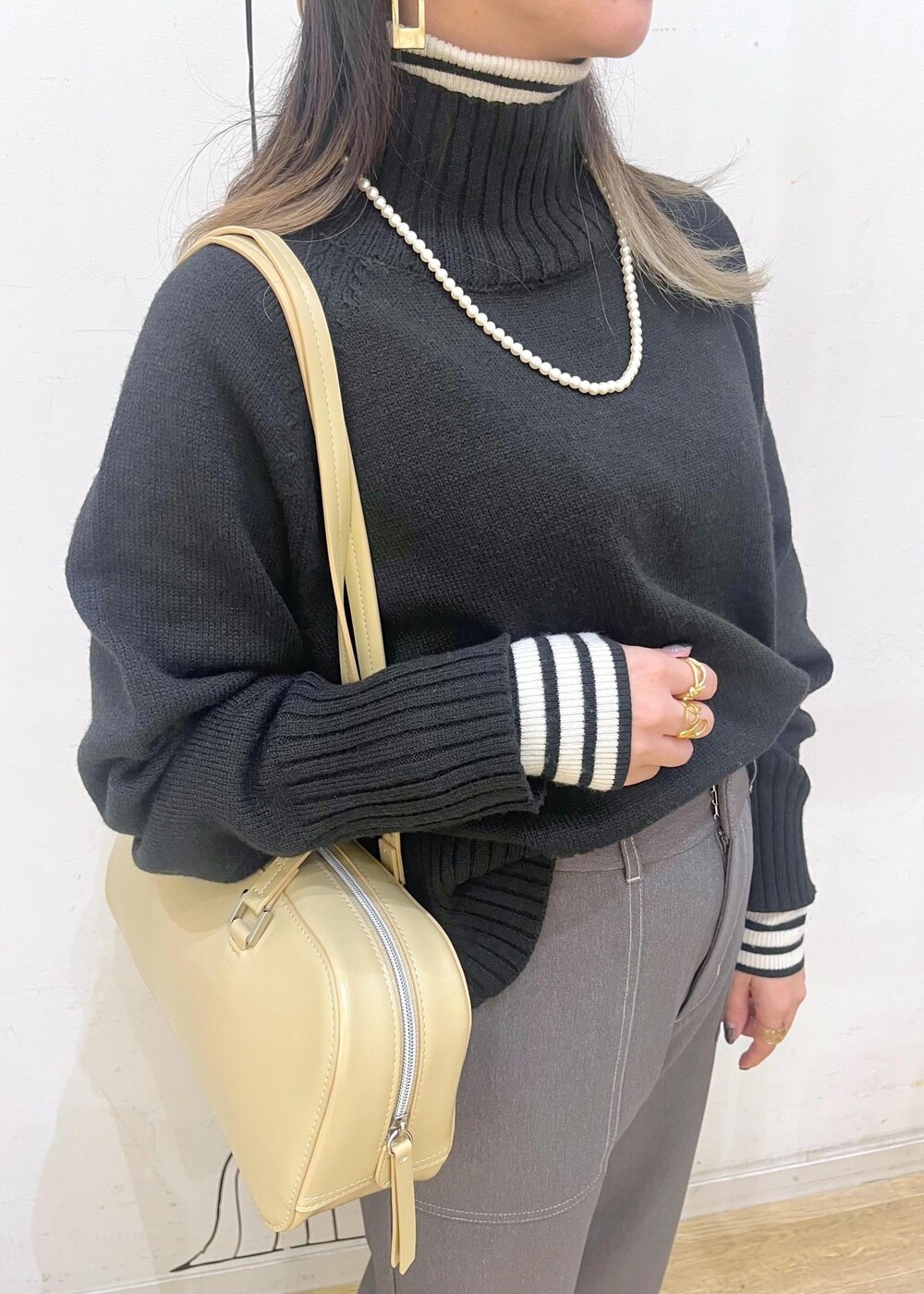 ベージュ系のローファー、ブラック系のニット/セーター、ホワイト系のニット/セーターを着用したレディースの冬コーディネートの6枚目の写真