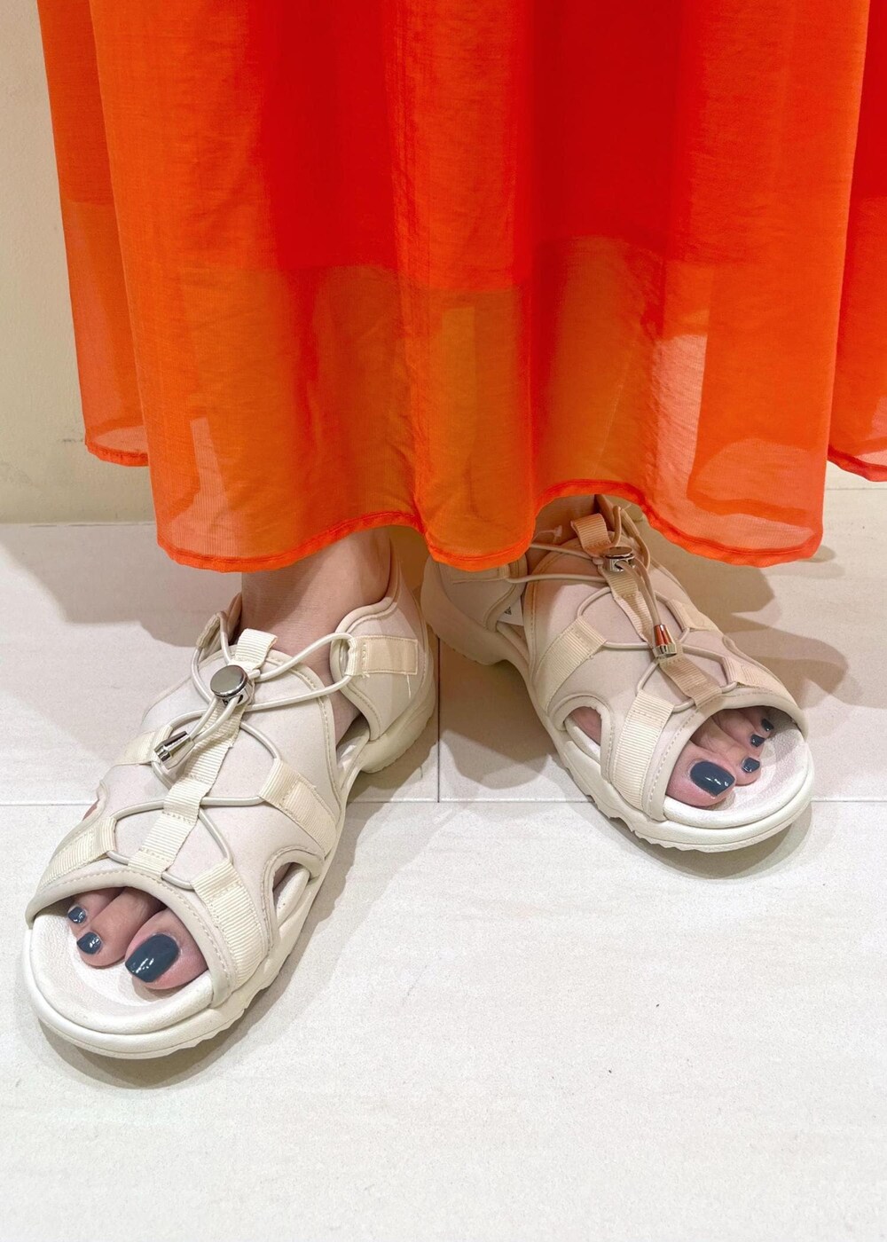 ブラック系のタンクトップ、ホワイト系のTシャツ/カットソー、ホワイト系のサンダルを着用したレディースの春コーディネートの10枚目の写真