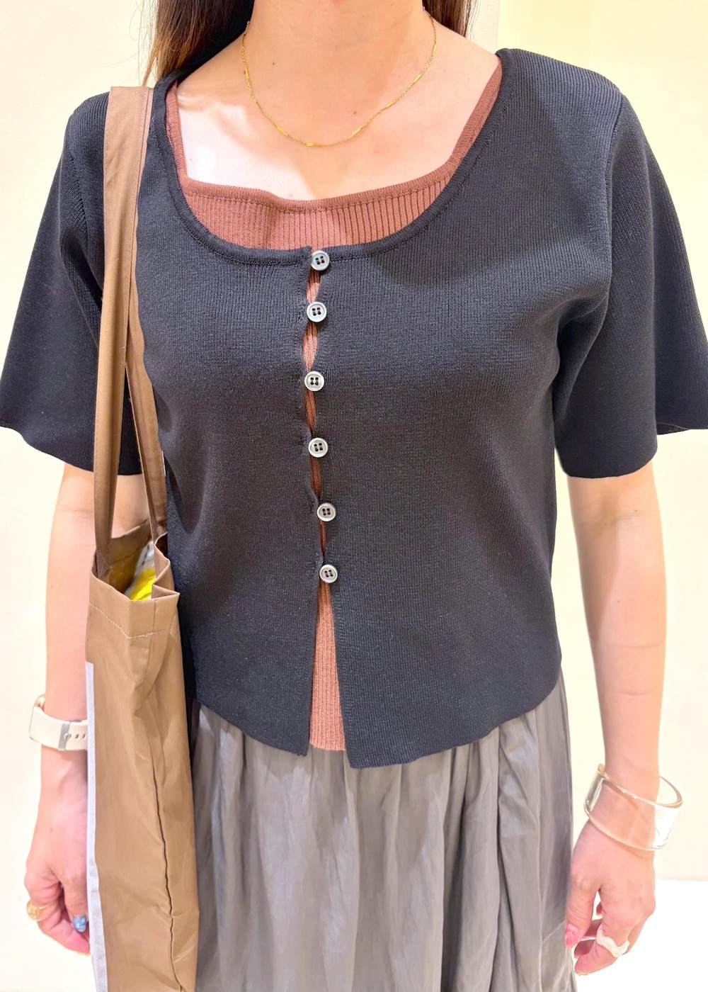 ブラウン系のサンダル、グレー系のスカート、ブラック系のカーディガン/ボレロを着用したレディースの春コーディネートの7枚目の写真
