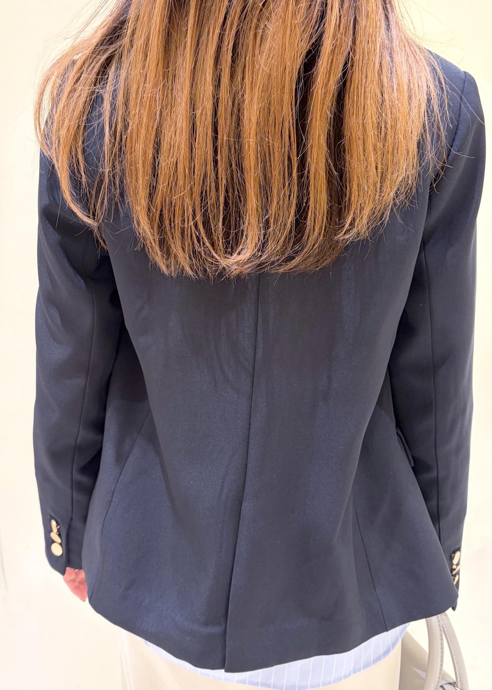 シルバー系のショルダーバッグ、ブルー系のテーラードジャケット、ブルー系のシャツ/ブラウスを着用したレディースの冬コーディネートの6枚目の写真